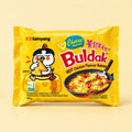 Samyang Buldak Cheese Ramen 140g yellow packet on a pale yellow background