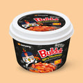 Samyang Buldak Hot Chicken Topokki Rice Cake Bowl 185g on a peach background
